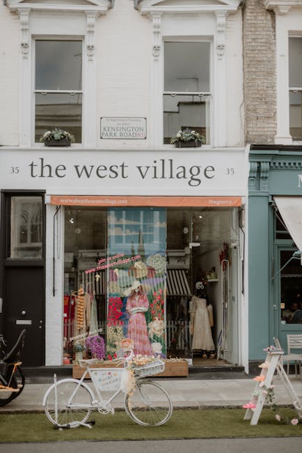 A floral display outside a boutique storefront on Kensington High Street, featuring an arrangement of fresh flowers in vibrant pinks, purples, and whites, artistically arranged on a small wooden table